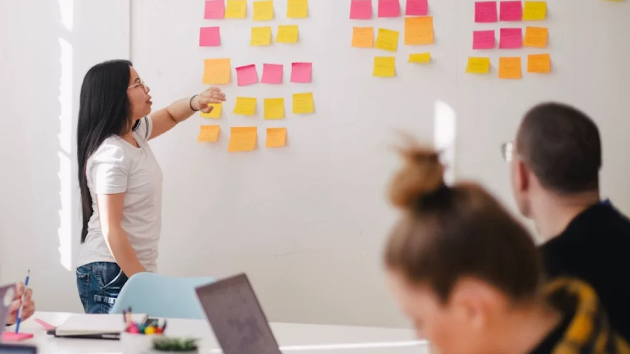 Workshop participants reviewing sticky notes on a wall